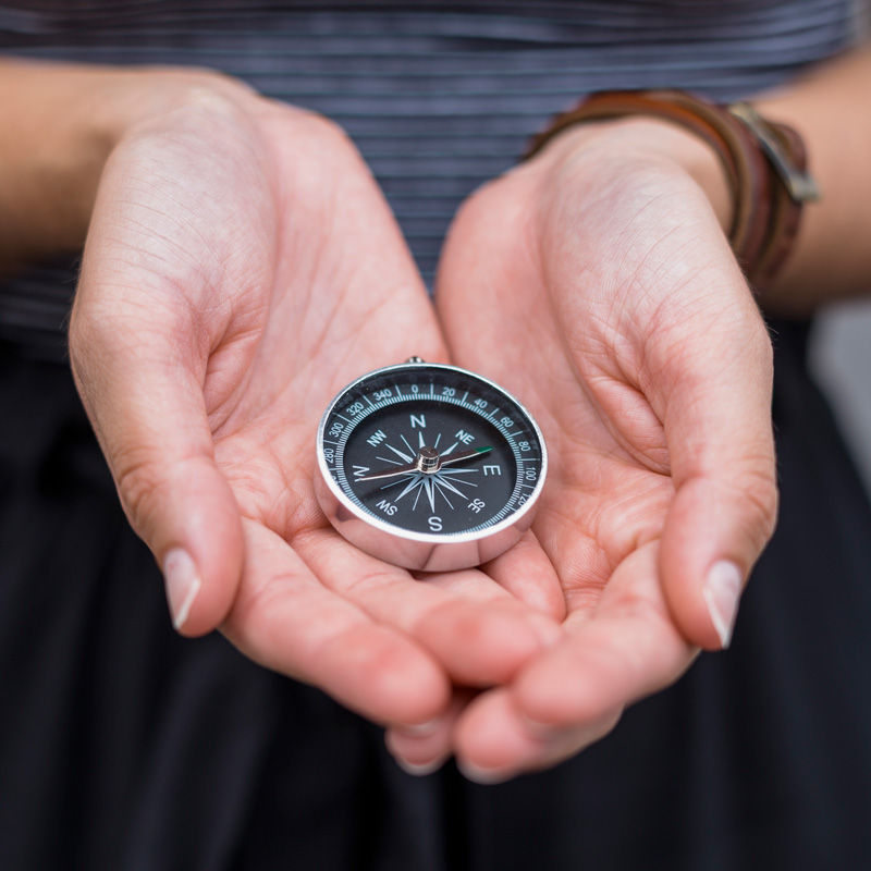 Photo of hands holding a compass